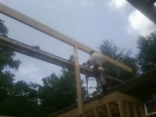 Carpenter setting a ridge beam over a new addition frame — Ice Dam Removal by Roofing Brothers in Rienzi