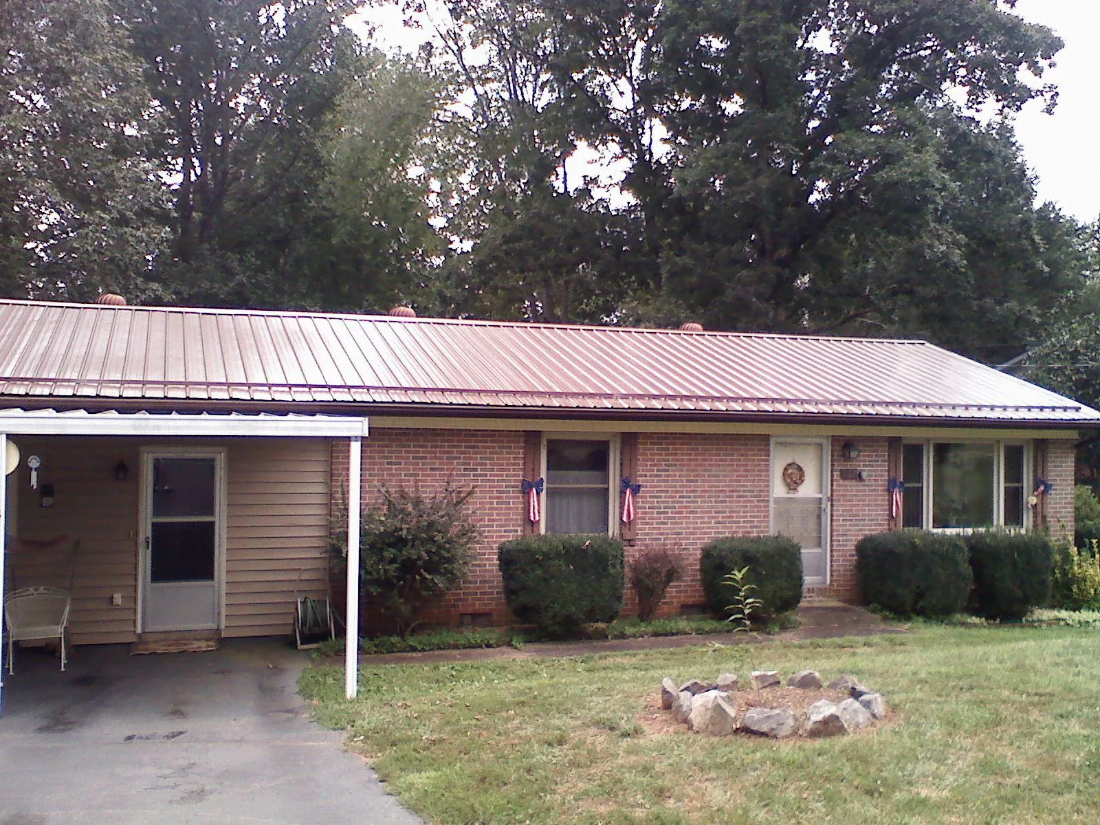 Bronze metal roof and carport on a brick ranch home — Roof Repair work by our crew in Rienzi