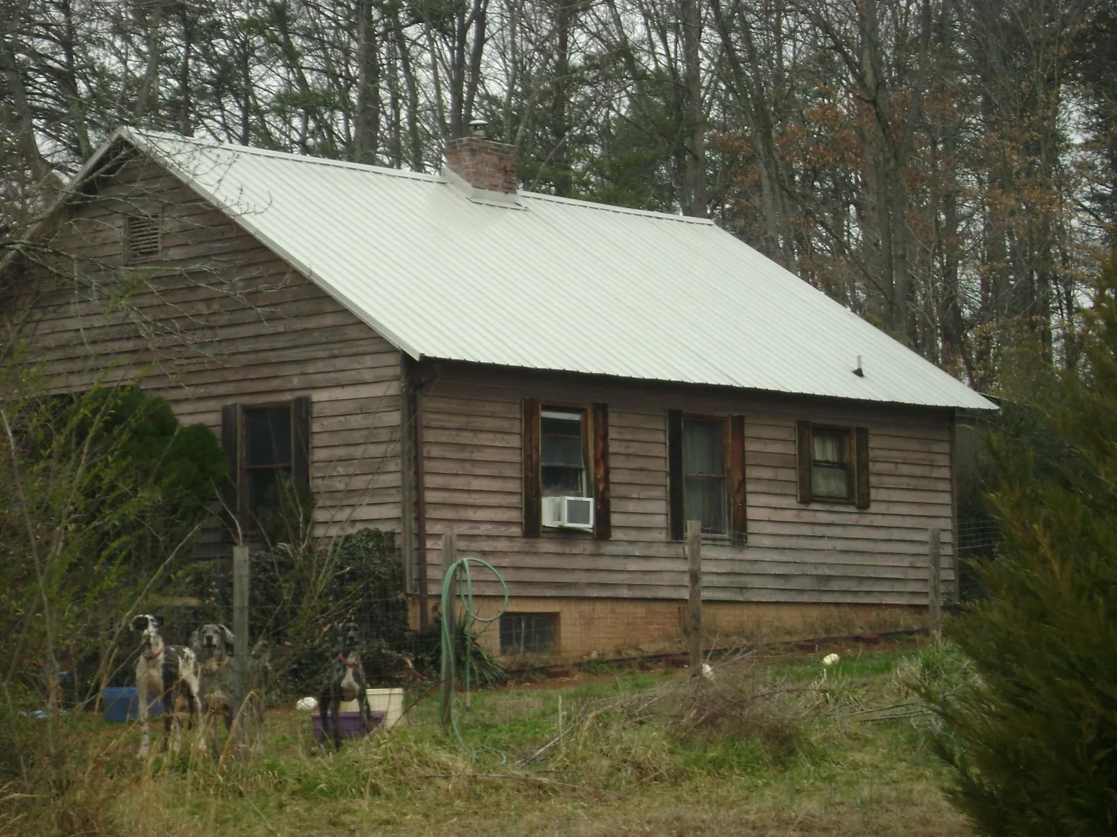 White metal roof on an old wood sided farmhouse, from a Metal Roof Installation job in Rienzi
